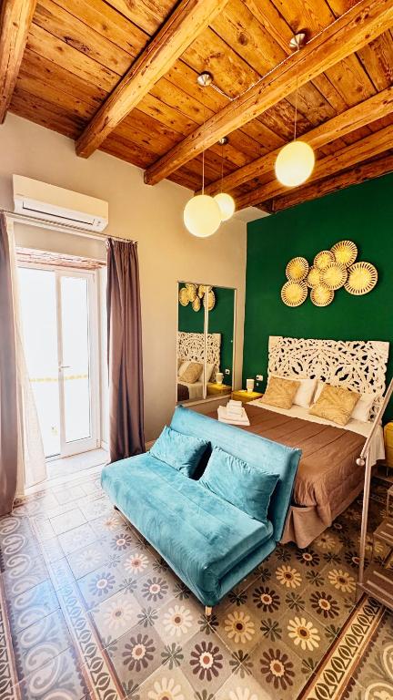 a bedroom with a large bed with green walls at Duomo Charming Rooms in Barletta