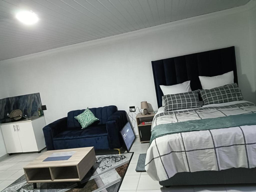 a bedroom with a bed and a couch at Mypeace Comfort in Pretoria