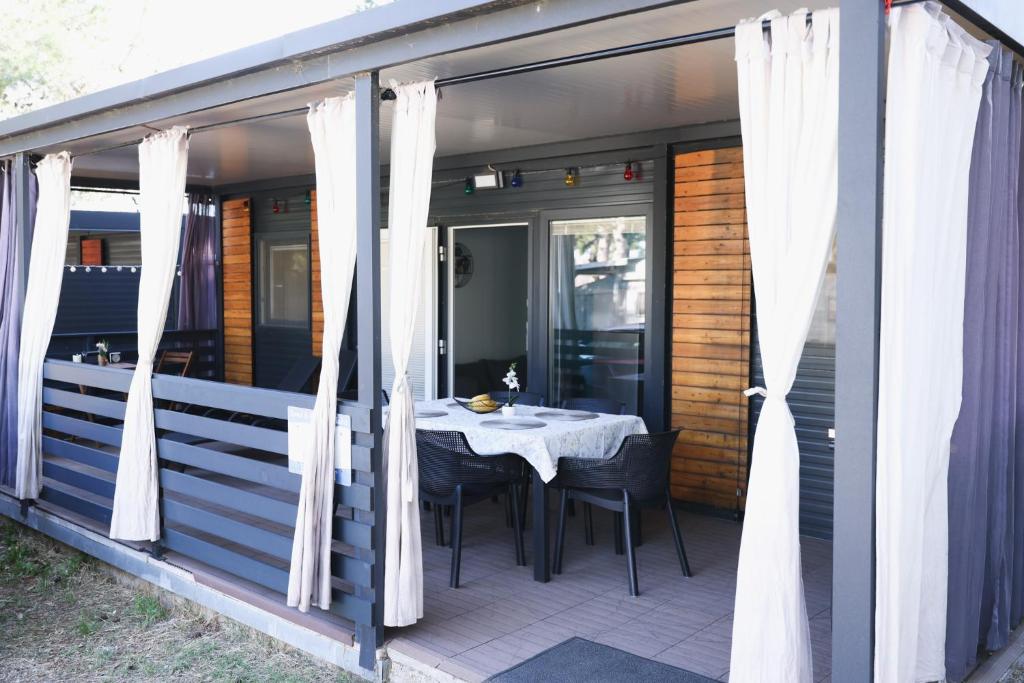 a dining table on the back porch of a house at Mobile Home ADRIA in Privlaka