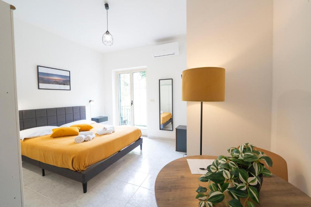 a bedroom with a yellow bed and a table at Palia's Hotel in Laino Borgo