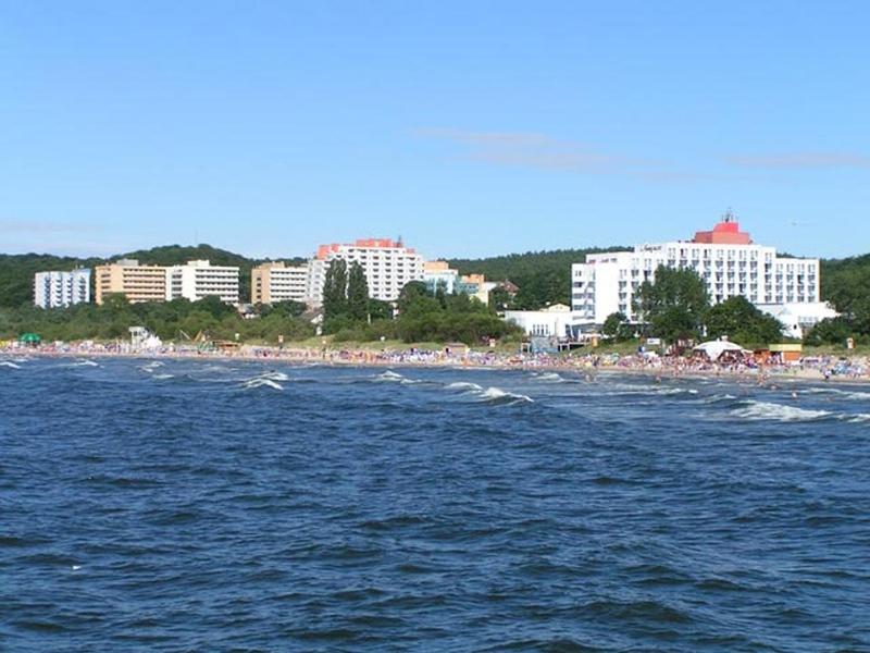 a body of water with a beach and buildings at Fala Patio with Balcony in Międzyzdroje