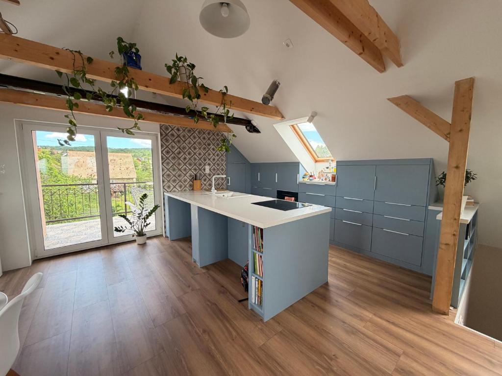 a kitchen with blue cabinets and a white counter top at Balaton Breeze in Balatonalmádi