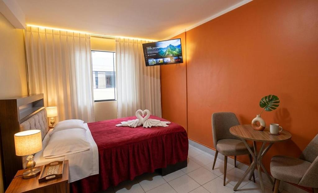a hotel room with a bed and a table with chairs at MiHOSTAL ELIAS in Tacna