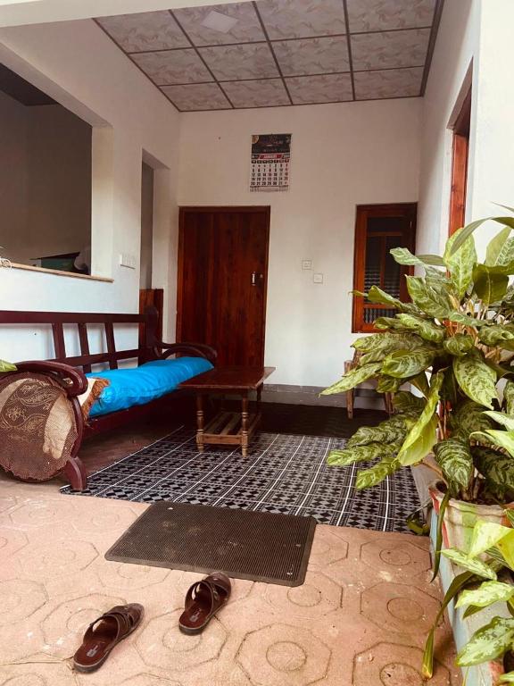 a living room with a bed and a pair of shoes at KR Villa in Arugam Bay