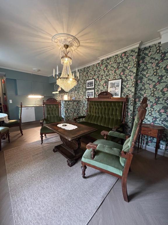 a living room with a table and chairs and a chandelier at Jugend 1902 in Ålesund