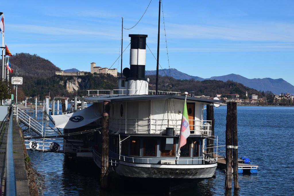 a boat is docked at a dock in the water at Piroscafo Lombardia in Arona