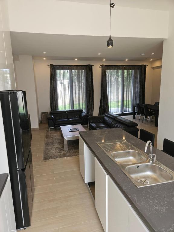 a kitchen and living room with a black refrigerator at Waterfront Accommodations Villa 3B in Bijilo