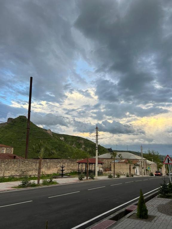 an empty street with a mountain in the background at Lucy Apartment Goris in Goris