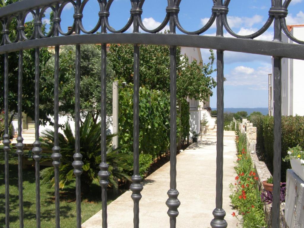 a gate to a garden with a sidewalk at Apartments Tina in Pula
