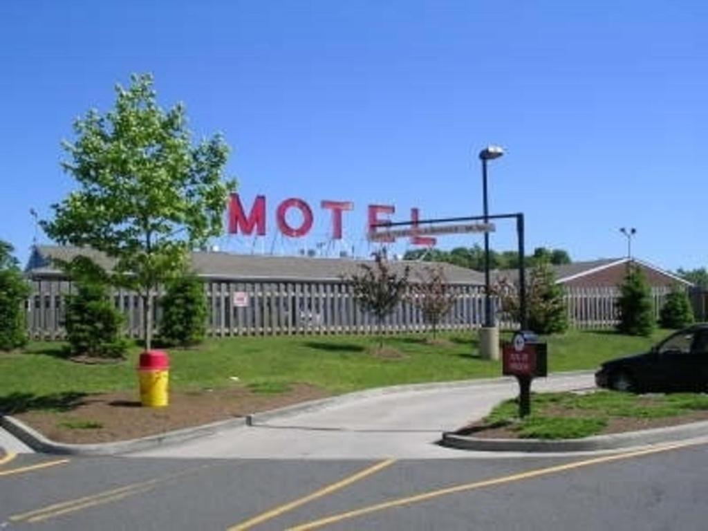 a motel sign on the side of a road at Mayflower Motel Milford in Milford