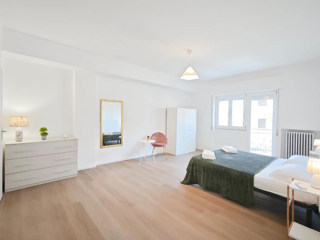 a white bedroom with a large bed and a desk at Dimora Leccese in Lecce