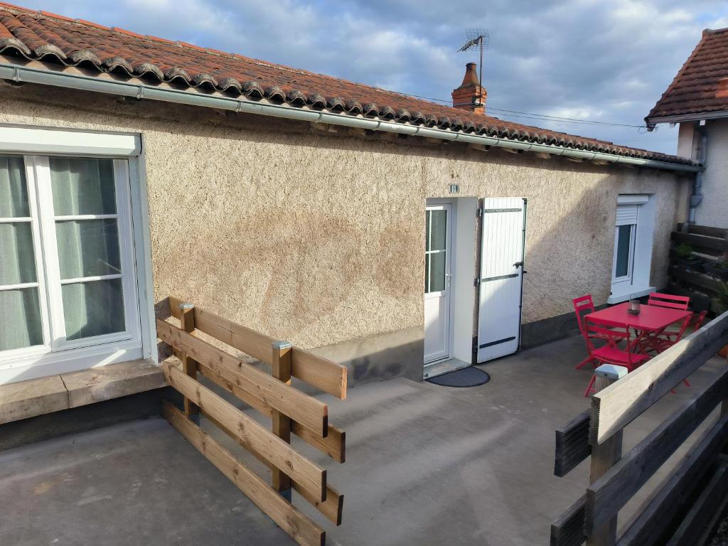 a patio with a wooden fence and a red table at La Ville Haute in Chauvigny