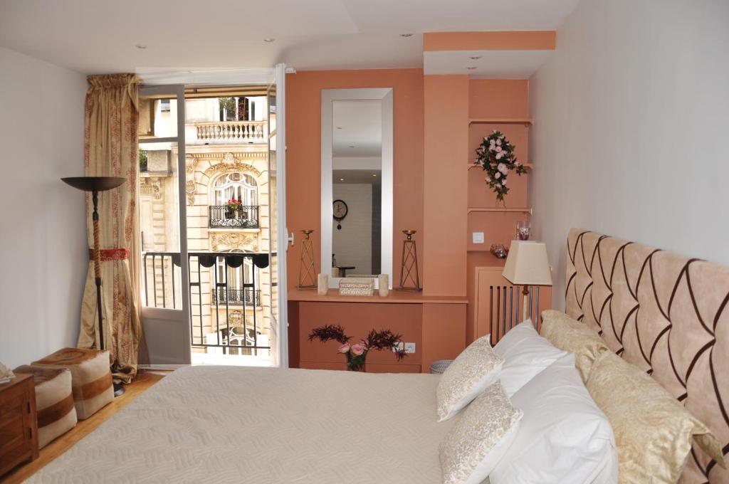 a bedroom with a bed and a large window at Champs Elysees Executive Apartment in Paris