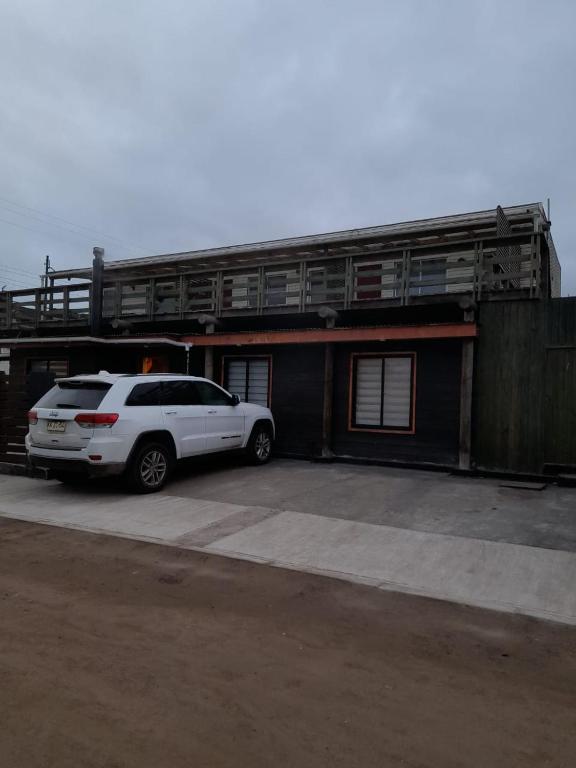 a white car parked in front of a building at Cabañas La Laguna de Zapallar in La Laguna