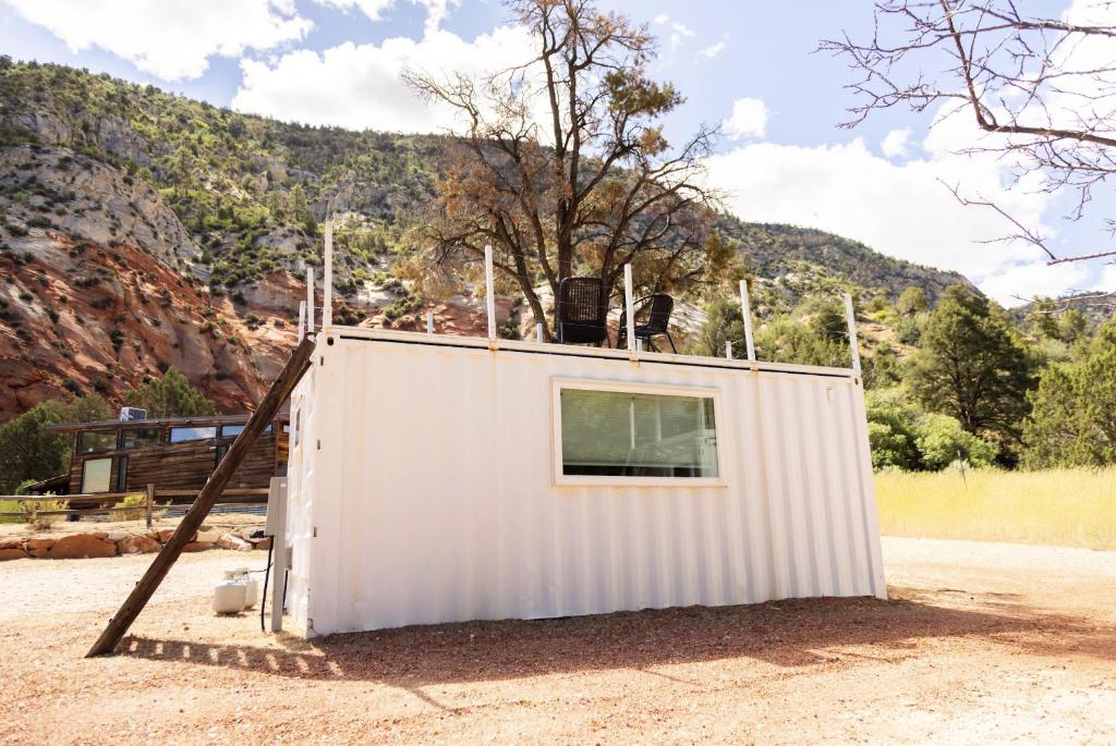 a small white building on the side of a road at NEW! Cozy Container Home at Cliffside #2 in Orderville