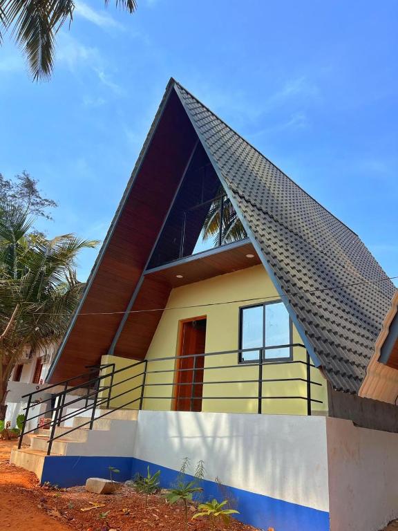 a house with a gambrel roof on top of it at Aastha Gokarna in Gokarn