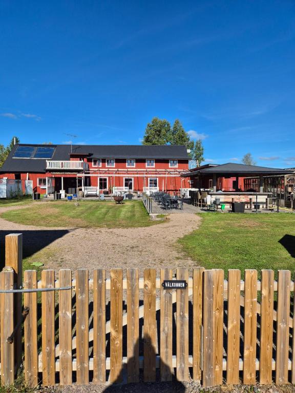 a wooden fence in front of a red barn at Charlottenlunds Gårdshotell & Restaurang in Långaryd
