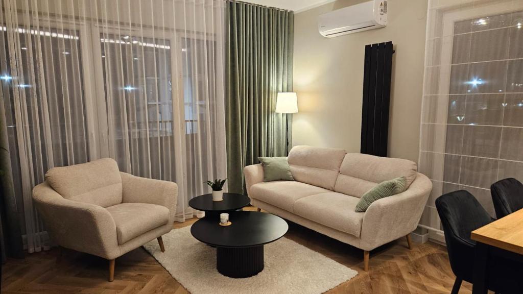 a living room with two chairs and a couch and a table at Jeziorna Premium Apartment in Siewierz