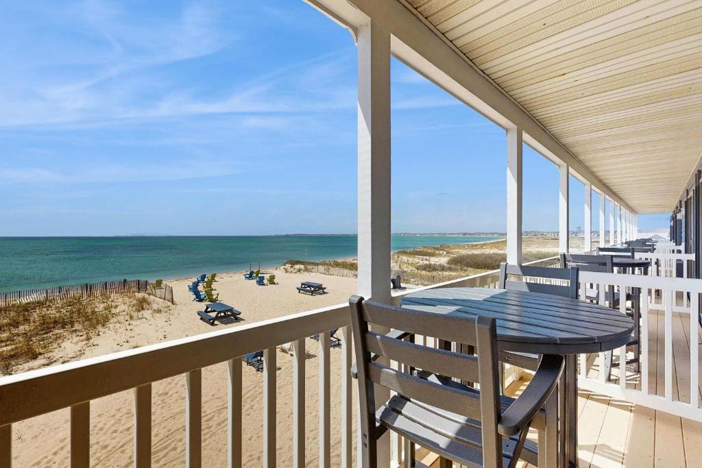 a balcony with a table and chairs on the beach at Oceanfront getaway with Bay-view balcony full kitchen AC in North Truro