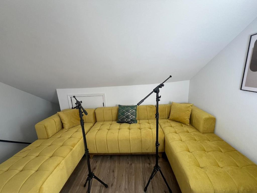 a yellow couch with two tripodars in a room at Philly Content House in Marcus Hook