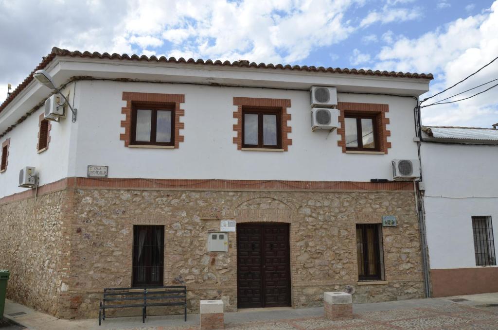 Casa blanca con ventanas marrones en Casa Rural Pastora Marcela, en Saceruela