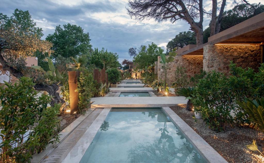 a swimming pool in the middle of a garden at Karidi Beach Gaia Retreat in Vourvourou