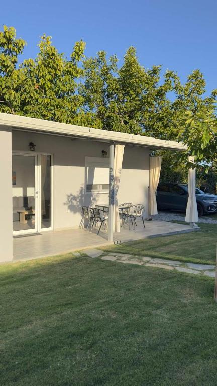a house with tables and chairs on a patio at Anemos Comfort Living in Paralia Panteleimonos