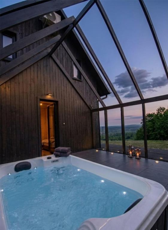 a large hot tub in front of a house at Zimna Woda 50 Brenna in Brenna