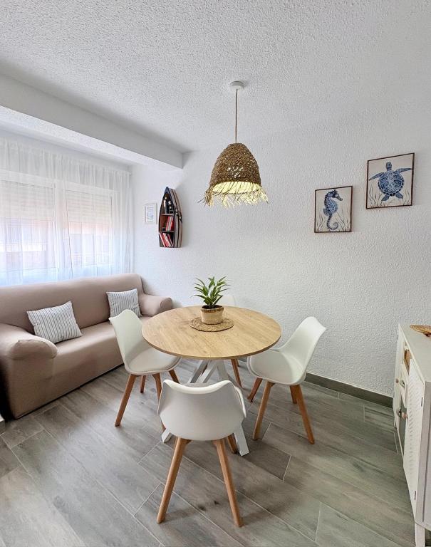 a living room with a couch and a table and chairs at Apartamento Galvana in Peniscola