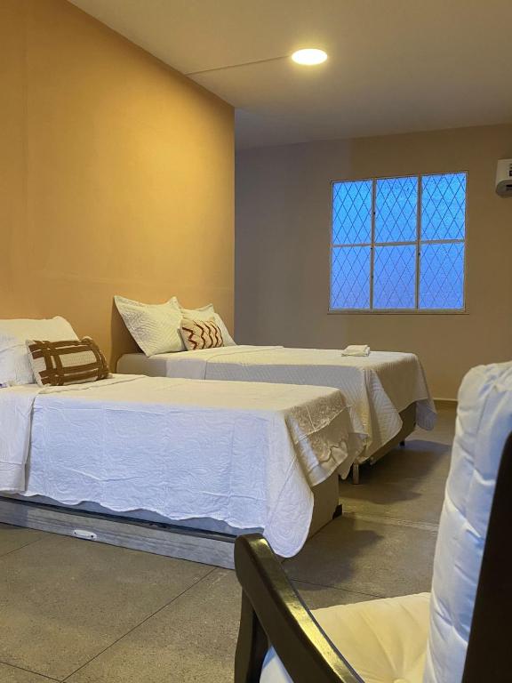 two beds in a hospital room with a window at Loft Campinho 1 in Estação Inhoaíba