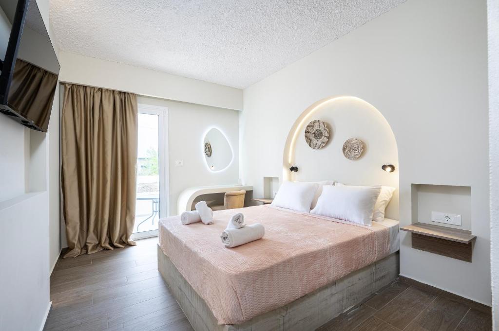 a bedroom with a large bed with two towels on it at SolMare Premium Suites in Mastihari