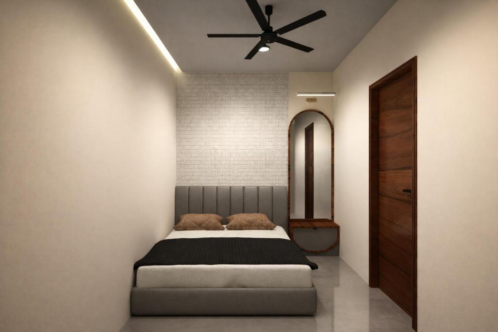 a bedroom with a bed and a ceiling fan at विठाई AC Rooms in Pandharpur