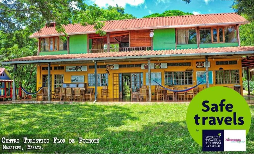 a house with a sign that reads safe travels at Hostal Flor de Pochote in Masatepe