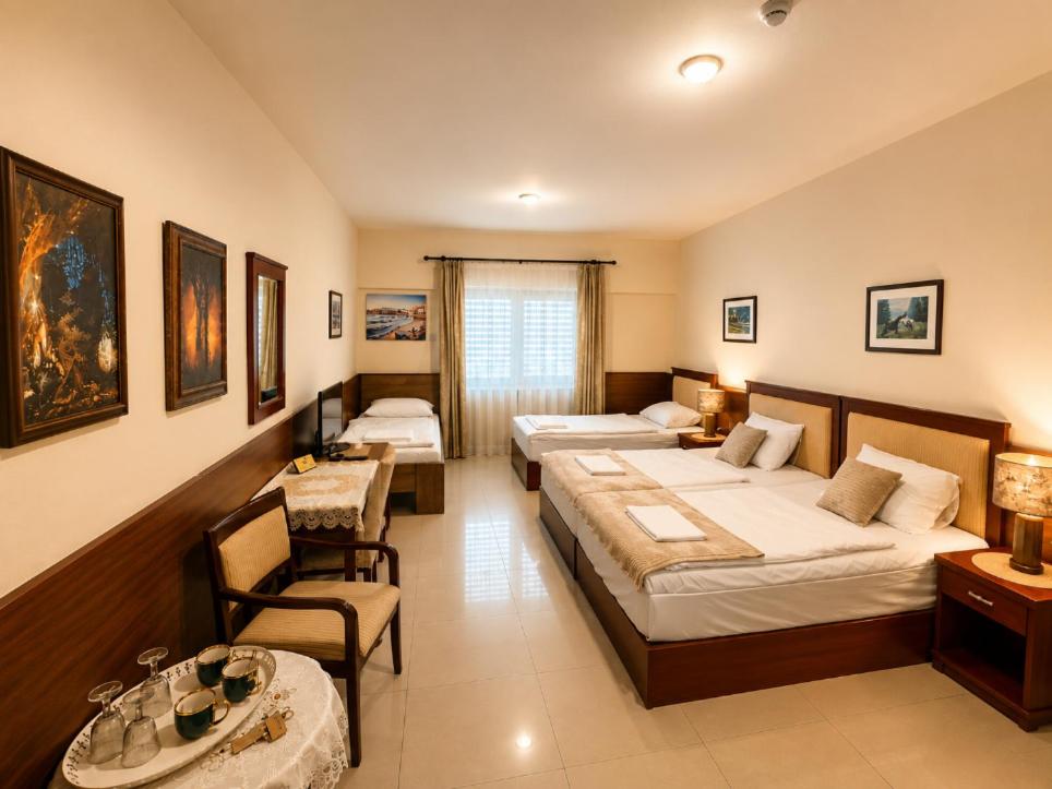 ein Hotelzimmer mit zwei Betten, einem Tisch und Stühlen in der Unterkunft Penzion RAKI in Bratislava
