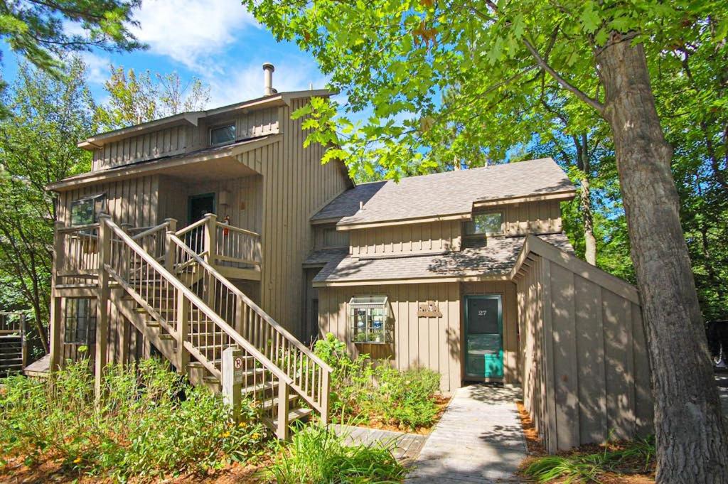 a small house with a staircase leading up to it at Hawks Nest 27 in Glen Arbor