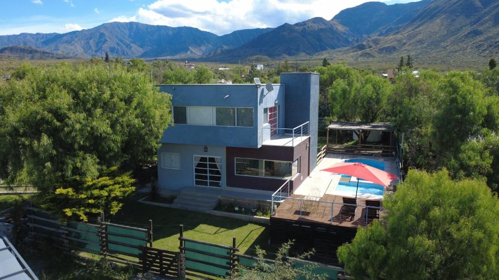a house with an umbrella and a swimming pool at Terrazas de la Quinta - Cabañas de Montaña in Mendoza