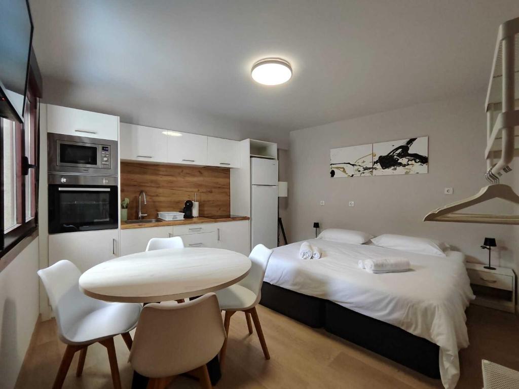 a bedroom with two beds and a table and chairs at Habitación con cocina en Muralla Lugo 1.3 C in Lugo