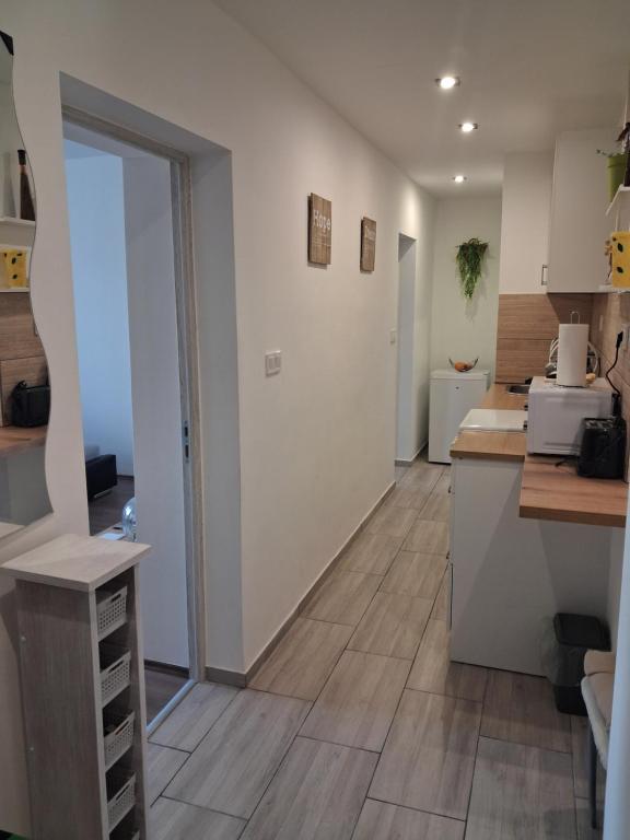 a kitchen with white cabinets and a wooden floor at Centralhome in Miskolc