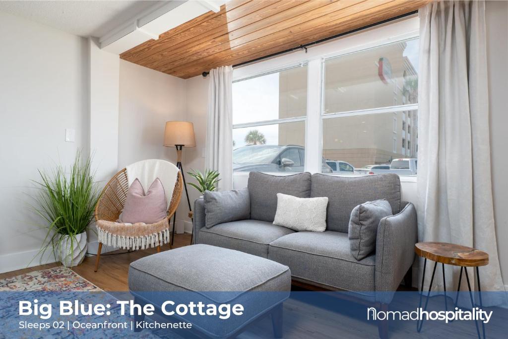 a living room with a couch and a window at Be A Nomad - Beach Cottage Oceanfront in Jacksonville Beach