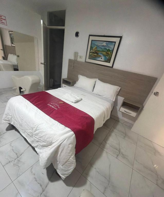 a bedroom with a large bed with a red and white blanket at hotel dominicos & parkas in Lima