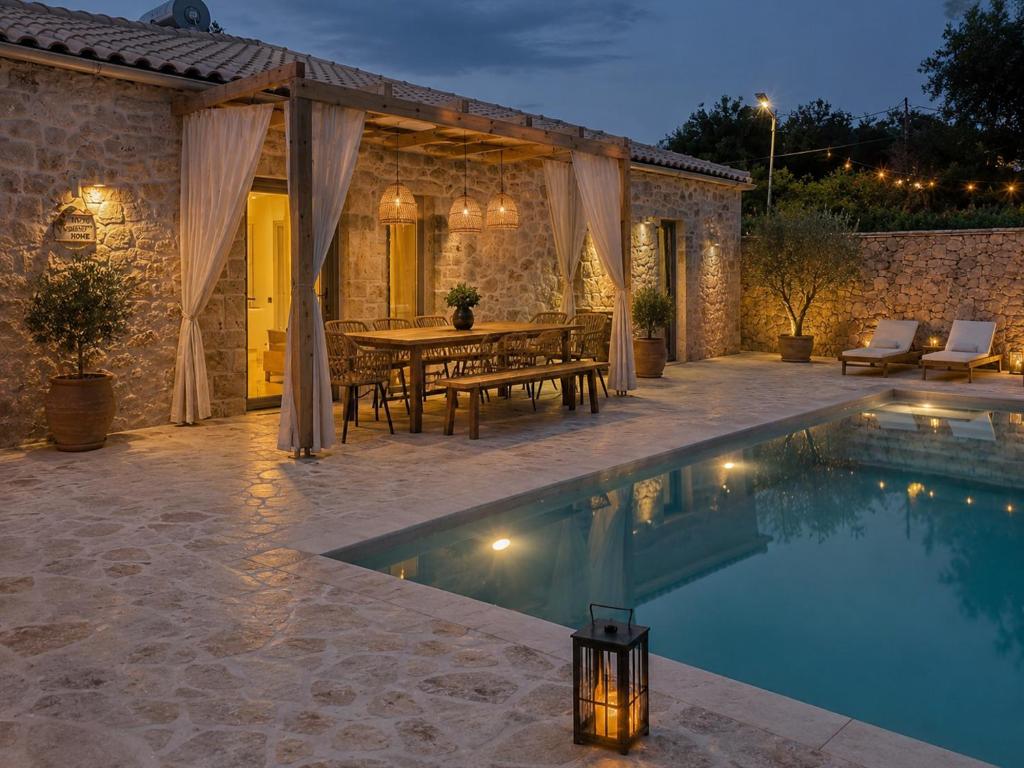 a patio with a table and a swimming pool at TS Luxury villa in Velianitátika