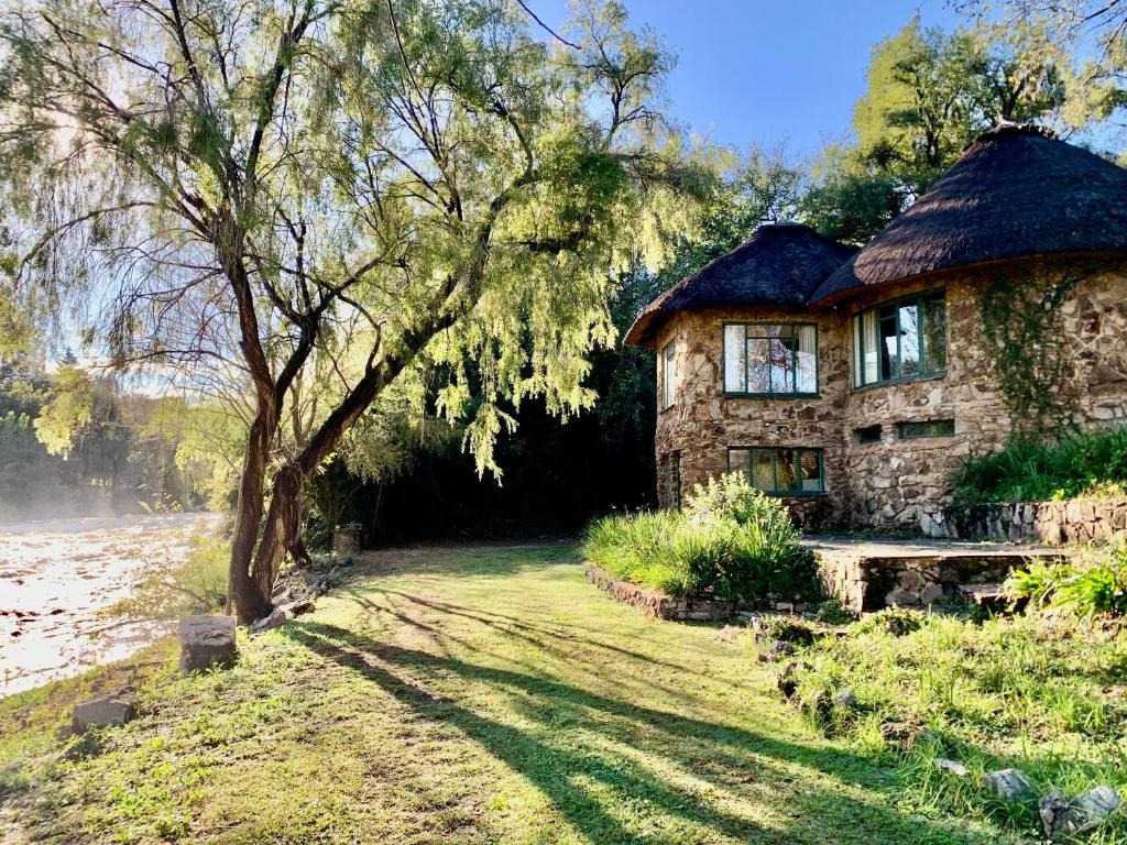 a stone house with a tree in front of it at Forestiva Farm - River Cottage in Centurion
