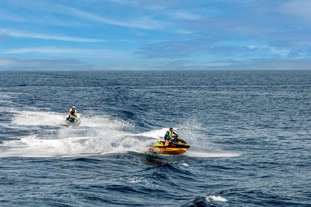 zwei Personen fahren auf einem Jetski im Wasser in der Unterkunft El Classicoo Apartment in Rubavu
