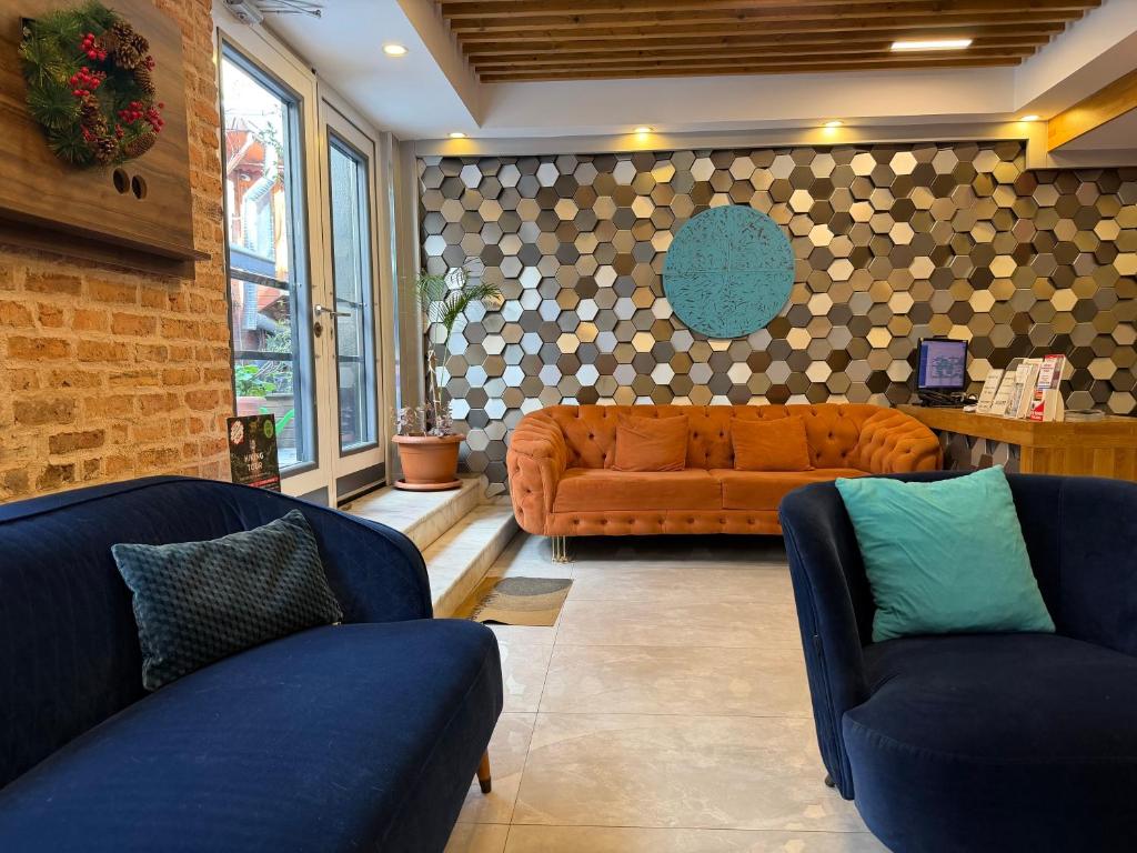 a living room with two blue chairs and an orange couch at The Basilissis Gulhane in Istanbul