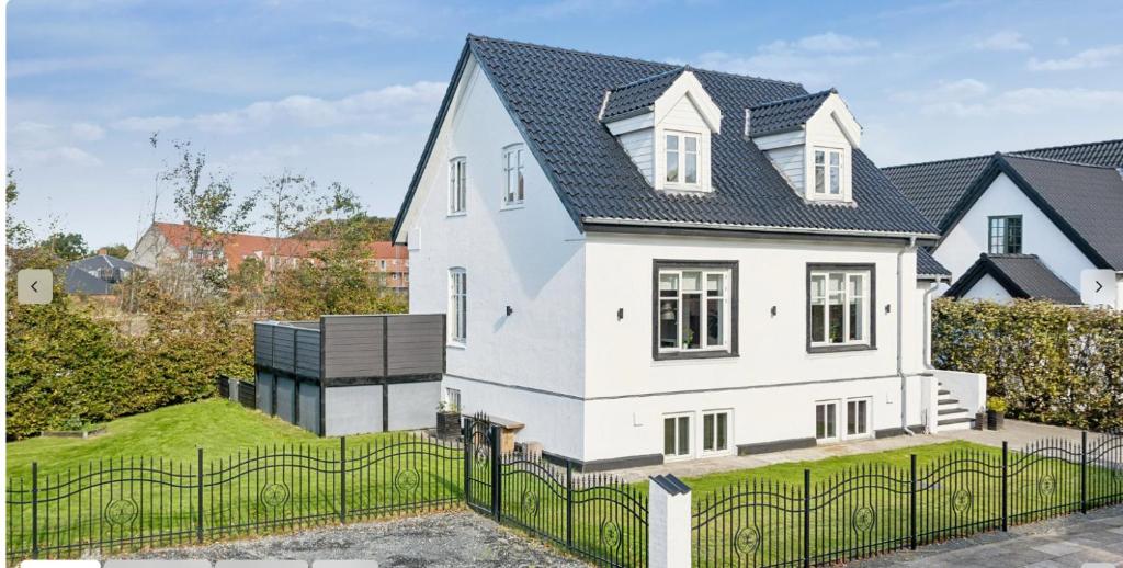 a white house with a black roof at patriciervilla i 2plan udlejes in Hjørring