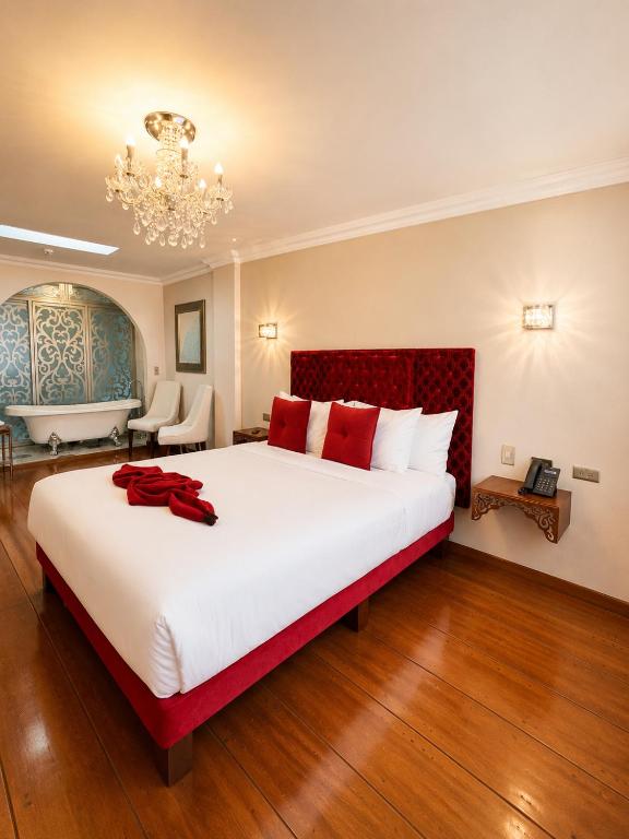 a large bedroom with a large white bed with red pillows at Dakani Hotel Boutique NEW in Quito