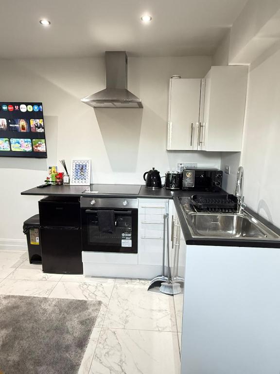 a kitchen with a sink and a stove top oven at One Bedroom Luxurious Flat - Free Parking in Rochester