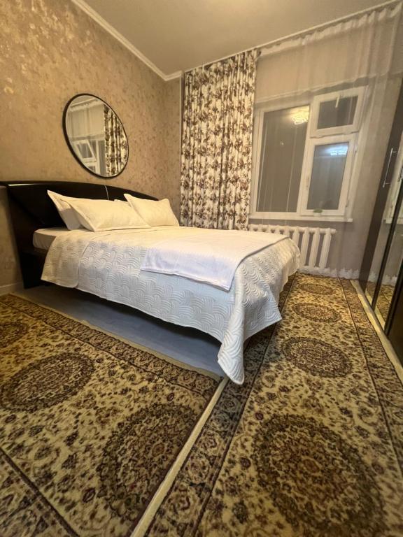 a bedroom with a large bed and a window at Уют как дома in Shymkent