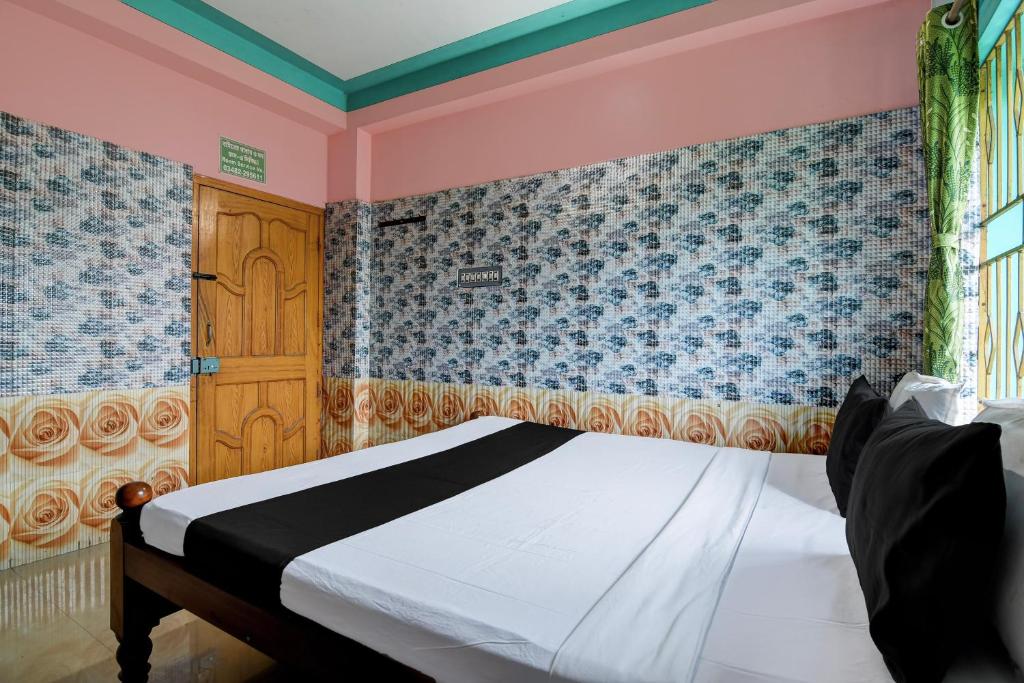 a bedroom with a bed and a blue and pink wall at Hotel O Green House in Lālbāgh