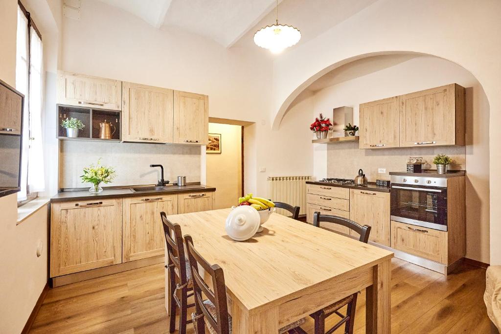 a large kitchen with a wooden table and chairs at La Dimora degli Olivi in Torrita di Siena